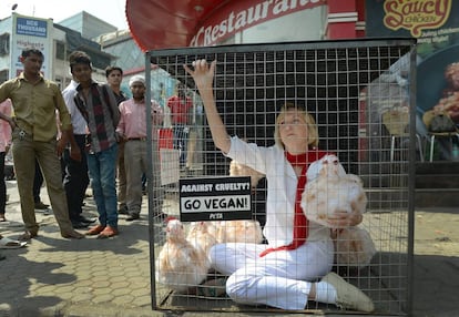 Newkirk en una protesta en Bombay en 2014, donde se encerró con varias gallinas y un cartel: “Contra la crueldad, hazte vegano”.