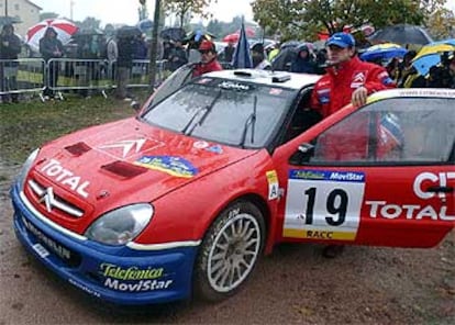 Carlos Sainz y su copiloto empujan su coche tras parársele por un problema electrónico.