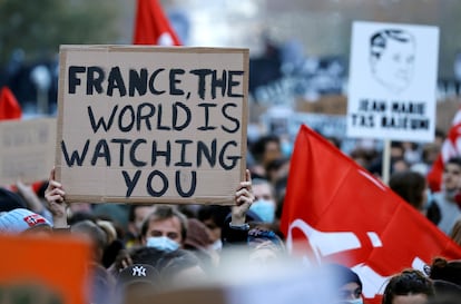 "França, o mundo está te observando", diz um cartaz na manifestação de sábado em Paris contra a lei de segurança, de Macron.