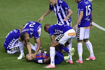 El defena del Barcelona Javier Mascherano (en el suelo)  es ayudado por los jugadores del Alavés después de golpearse la cabeza.