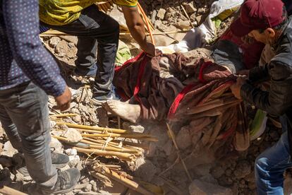 Voluntarios rescatan el cadáver de una víctima del seísmo,  en Tafeguagut.