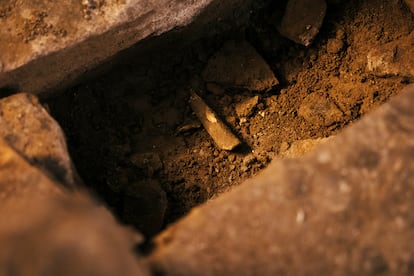 Un hueso humano sin identificar en la tierra de relleno de la necrópolis medieval de Santiago de Compostela.