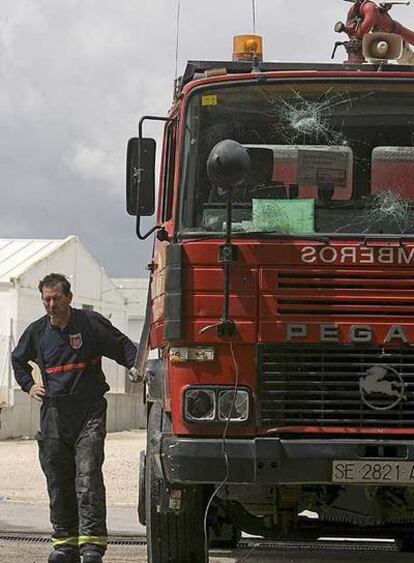 Un bombero, junto al camión apedreado por varios vecinos.