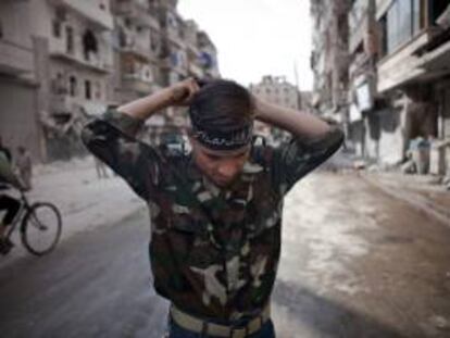 Imagen cedida el 11 de octubre de 2012 de un militar del Ejército Sirio Libre ajustándose una cinta a la cabeza en las calles de Alepo, Siria hoy, jueves, 11 de octubre de 2012.