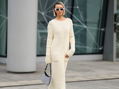 Mujer rubia por la calle con un vestido maxi largo en color beige.