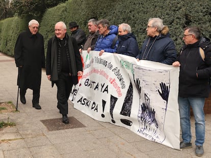 Dos prelados pasan por delante de algunas de las víctimas de abusos en la Iglesia que se han manifestado este lunes en la puerta de la Conferencia Episcopal, en Madrid.