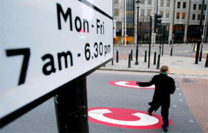 Un londinense cruza ayer la calle sobre un signo C <i>(congestion,</i> atasco), que marca la entrada en zona de peaje.