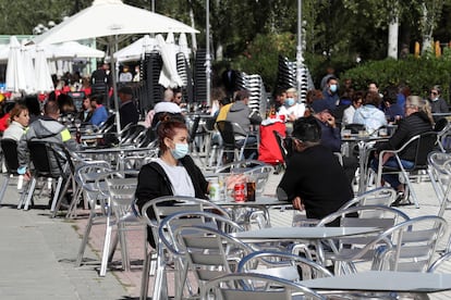 Varios clientes conversan en la terraza de un bar en Aluche (Madrid).