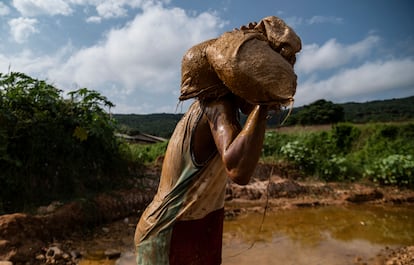 Con cubetas metálicas, los chicos dragan primero los pozos para evitar que se inunde con agua. Cuando está casi seco comienzan a sacar tierra y piedras buscando oro.
En la imagen, un minero camina, bajo el intenso sol y con la espalda doblada por el saco que lleva a cuestas, hacia otro pozo cercano.