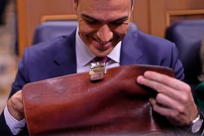 Sánchez abre su cartera a su llegada al hemiciclo para asistir a la sesión de tarde de la primera jornada del debate de investidura. 