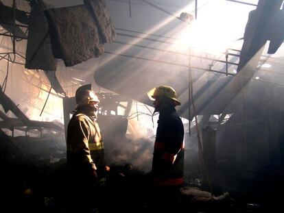 Zona industrial de Cuautitlán Izcalli, Estado de México.  Dos bomberos hablan tras varias horas de trabajo para controlar el  incendio en una fábrica de textiles.