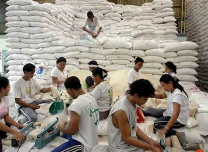 Trabajadores filipinos empaquetan bolsas de arroz para su distribución.