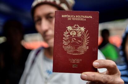 Una mujer venezolana muestra su pasaporte frente a la oficina de inmigración colombiana en Tulcán (Ecuador). 