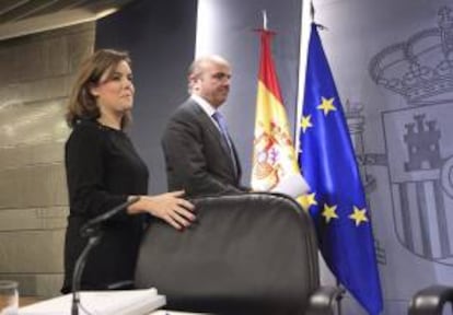 La vicepresidenta del Gobierno, Soraya Sáenz de Santamaría, y el ministro de Economía y Competitividad, Luis de Guindos, momentos antes de la rueda de prensa que han ofrecido tras la reunión del Consejo de Ministros, hoy en Madrid.