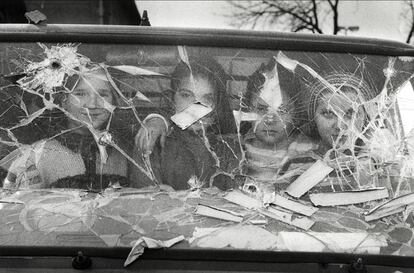 Cuatro niñas miran desde el interior de una furgoneta con el cristal destrozado en Sarajevo.