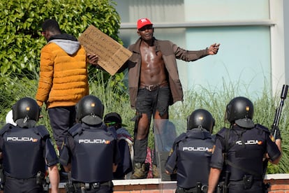 Dos temporeros protestan frente a agentes de la Policía Nacional fuera de la Institución Ferial de Albacete.