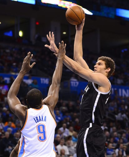 El jugador de los Nets Brook López lanza ante la marca de Serge Ibaka, de los Thunders de Oklahoma.