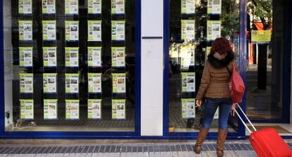 Anuncios de viviendas en venta en el escaparate de una inmobiliaria en Madrid.