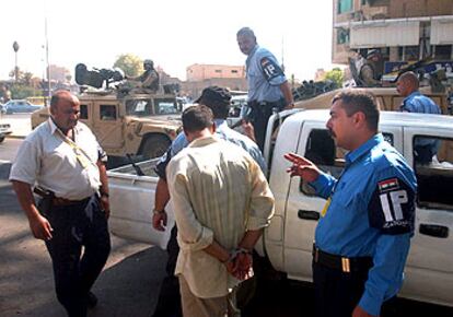 Policías iraquíes detienen a un hombre por conducir en el sentido contrario ayer en el centro de Bagdad.