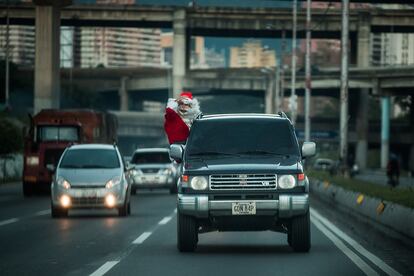 Un joven vestido de Santa Claus se asoma por la ventanilla de un vehículo en Caracas (Venezuela), el 3 de diciembre de 2016.