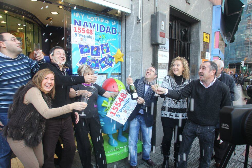 En Bilbao, en la calle Urkixu Zumarkalea, está la Lotería Ormaechea. En la imagen, vecinos y gerentes de la Administración de Lotería Ormaechea de Bilbao festejan un premio con champán.