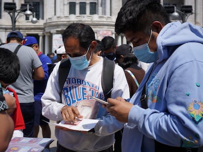 Aficionados a las cartas de Panini repasan sus listas de repetidas para ver si pueden intercambiar, el sábado 15 de octubre frente al palacio de Bellas Artes, en el centro de Ciudad de México.