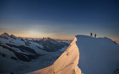 Una pareja de alpinistas en la cima del Jungfrau (4.158 metros) en el Oberland bernés (Suiza).