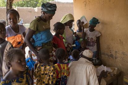 Fatoumatou Diarra, 32 años y madre de siete, espera con otros niños a recoger alimentos terapéuticos listos para usar con receta en el pueblo de Guihoyo. Algunos de sus hijos fueron sometidos a pruebas de malaria y malnutrición antes de recibir CPS y alimentos listos para ingerir.