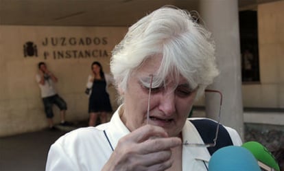 The mother of Antonio Meño, Juana Ortega, wipes away her tears on Thursday morning outside a Madrid courtroom. The family has been awarded just over one million euros in compensation after a plastic surgery procedure left their son in a coma 22 years ago.