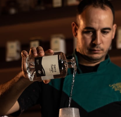 Mario Villalón con su destilado 'Tierra y Fuego', con base de productos como el musgo silvestre, pieles de queso Gamoneu o pimientos rojos asados de la casa, en la coctelería Angelita de Madrid.