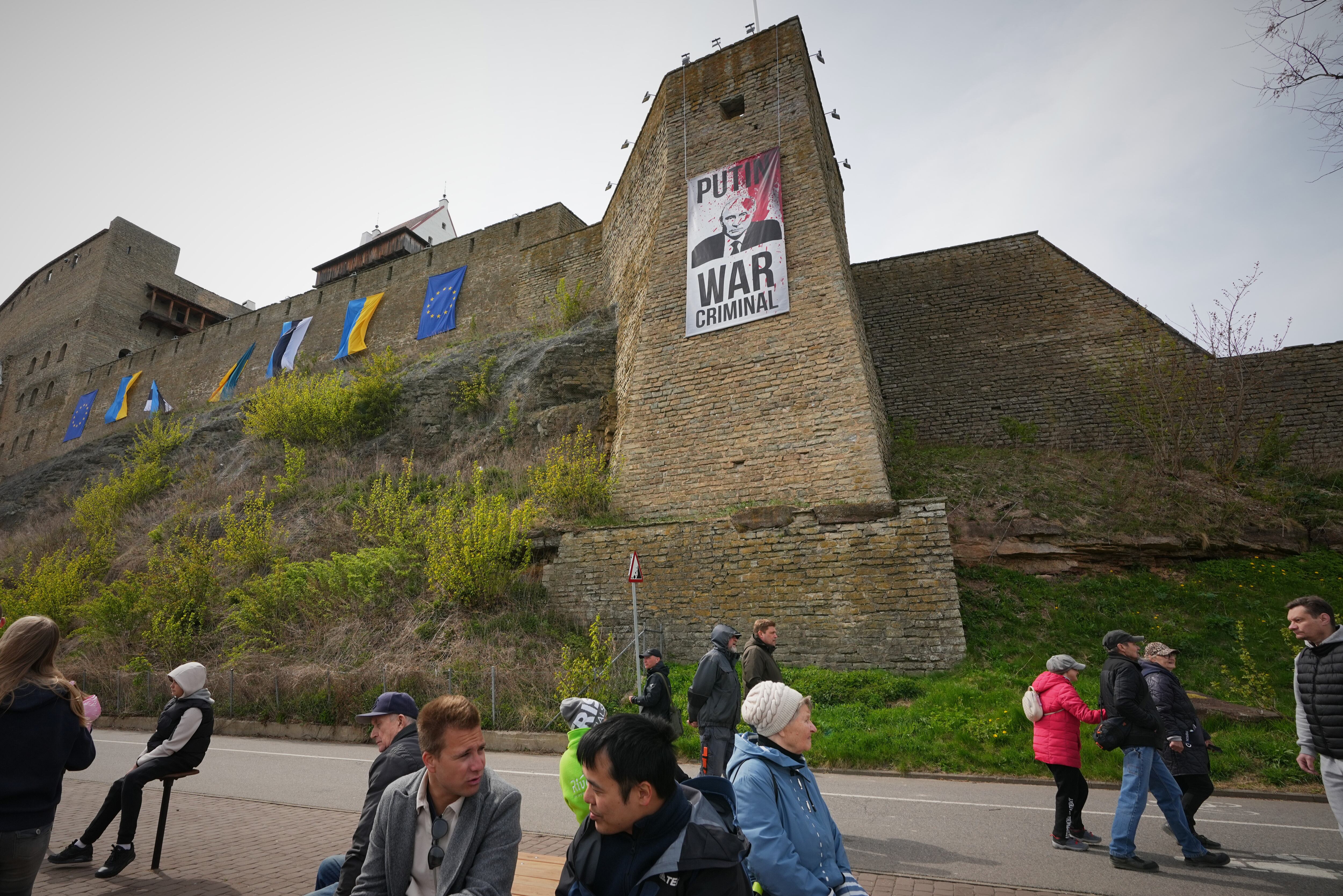 Un cartel que llama a Vladímir Putin criminal de guerra, colgado de un muro del castillo de Narva, en Estonia, el 9 de mayo. 