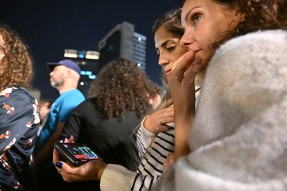 Familiares de los rehenes israelíes en Tel Aviv, siguiendo las noticias a través de sus teléfonos móviles.