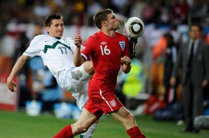 El eslovaco Andraz Kirm mete la pierna para hacerse con el balón ante la cara de James Milner.