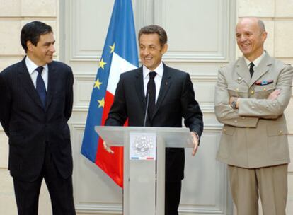 El presidente francés, Nicolás Sarkozy, entre el primer ministro, Francois Fillon (izquierda), y Jean Georgelin, jefe de la Armada