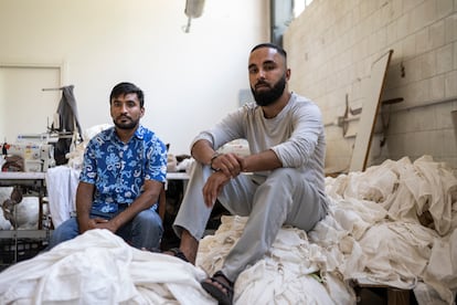Ullah Zakha, a la derecha, y otro trabajador de la empresa Confezioni San Martino, dentro de la fábrica que ocupan desde hace un mes, el pasado miércoles.