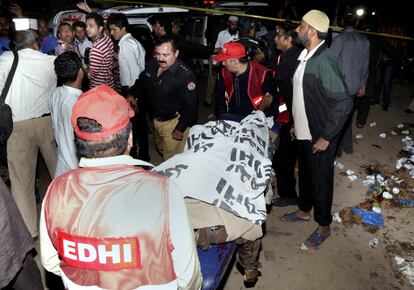 Los trabajadores de rescate paquistaníes retiran algunos cadáveres del lugar de la explosión de una bomba en un parque en Lahore, Pakistán.