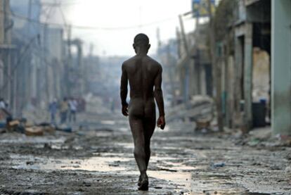 Un hombre camina desnudo y desorientado por una calle arrasada de Puerto Príncipe.