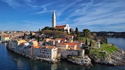 Para muchos, Rovinj es el pueblo más bonito de Croacia. Y también la mayor atracción de la costa de Istria porque, a pesar de los muchos turistas que visitan en verano esta península, y de que no ofrece demasiados puntos concretos de interés, Rovinj tiene muchísimo encanto. Y es que es uno de esos lugares en los que solo apetece pasear por sus calles y rincones, pararse en las pequeñas tiendas de artesanía o tomar un café en alguna de sus placitas. Fue una islita hasta que en 1763 se rellenó el estrecho canal para conectarla con tierra firme. El Stari Grad, el casco antiguo, es la zona más bonita y la que mejor conserva la esencia histórica. Sus empinadas calles y placitas ocupan una península ovalada, presidida por un campanario en su punto más alto. La principal zona residencial de Rovinj se extiende a espaldas del casco viejo por las laderas de las bajas colinas que lo rodean, mientras que los hoteles estilo <i>resort</i> bordean la costa al norte y sur. Cuando el bullicio se apodera del pueblo, podremos escaparnos a alguna de las 14 islas del archipiélago de Rovinj.