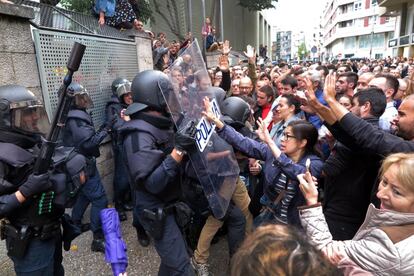 Forcejeos entre ciudadanos y policía ante un colegio electoral en Girona durante la jornada de votación del referéndum de autodeterminación, el 1 de octubre de 2017.