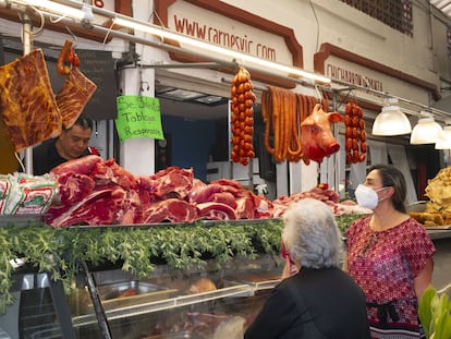 Dos mujeres compran carne en un mercado en Cholula (Puebla).