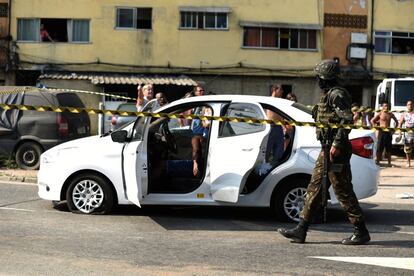 Soldado caminha próximo ao carro alvejado pelos tiros do Exército. 