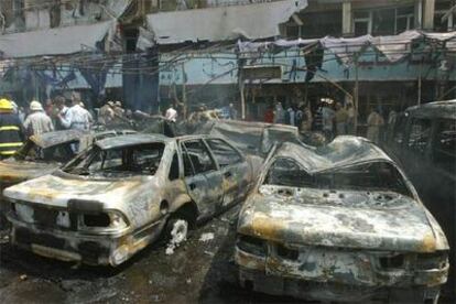 Varios coches calcinados en el aparcamiento del restaurante de Bagdad donde ha estallado el coche bomba.