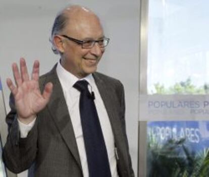 El ministro de Hacienda, Crist&oacute;bal Montoro, saluda antes de su intervenci&oacute;n en la Escuela de Verano del PP que se celebra en El Escorial. 