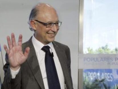 El ministro de Hacienda, Crist&oacute;bal Montoro, saluda antes de su intervenci&oacute;n en la Escuela de Verano del PP que se celebra en El Escorial. 