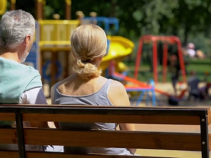 Una pareja observa a los niños en un parque.