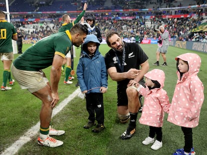 El sudafricano Damian de Allende, a la izquierda, conversa con el neozelandés Samuel Whitelock, quien le presenta a sus hijas tras la final del Mundial que ganó Sudáfrica a Nueva Zelanda.