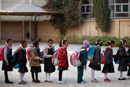 Niñas esperando el autobús para ir al colegio a las puertas de un orfanato en Sanaa, Yemen.