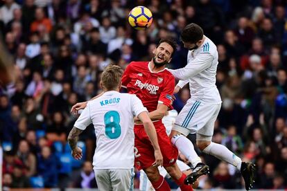 Franco Vázquez (centro) golpea el balón de cabeza con la presión de Nacho Fernández (derecha) y Toni Kroos.