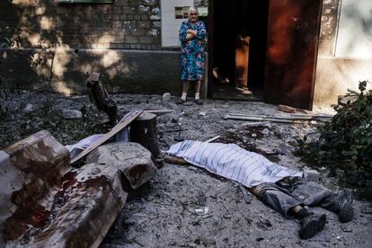 Una anciana mira el cuerpo que yace sobre el suelo después de un bombardero en Donetsk. Tres civiles murieron en bombardeos donde el ejército de Kiev está luchando contra los separatistas prorrusos.