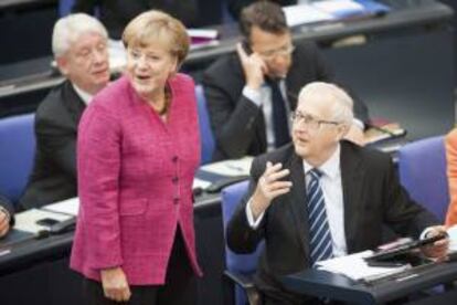 La canciller alemana, Angela Merkel (izq), habla con el jefe del grupo parlamentario liberal, Rainer Brüderle, en el Bundestag, Cámara baja del Parlamento germano, en Berlín, Alemania.